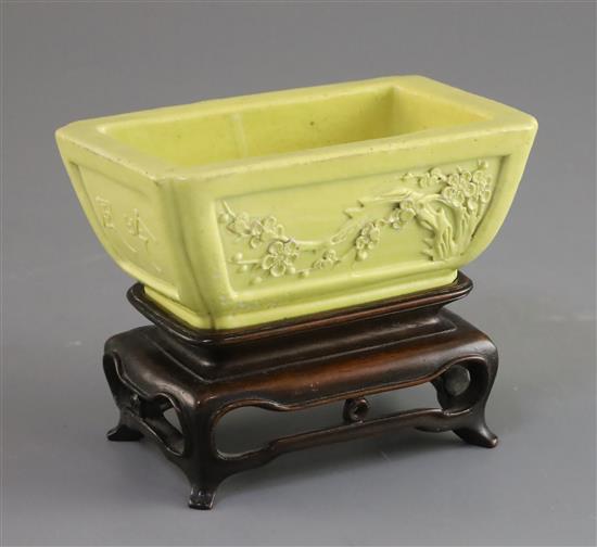 A Chinese yellow glazed biscuit model jardiniere, Qing dynasty, L. 10.3cm, wood stand